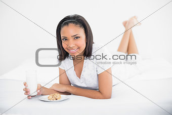 Attractive young dark haired model enjoying milk and cookies