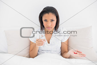 Stern young dark haired model taking medication