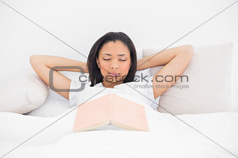 Relaxed young dark haired model sleeping in her bed
