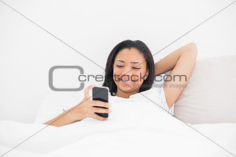 Relaxed young dark haired model using a mobile phone