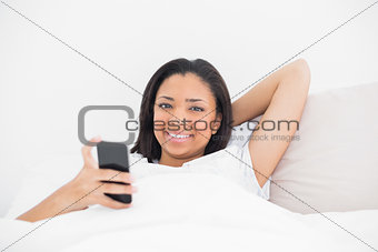 Peaceful young dark haired model using a mobile phone