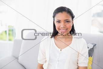 Smiling young dark haired woman in white clothes looking at camera