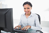 Content young dark haired businesswoman typing on her computer