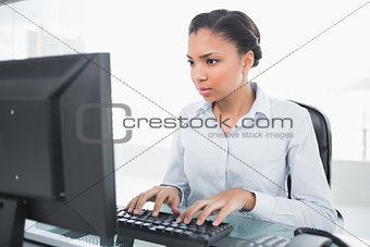 Concentrated young dark haired businesswoman using a computer