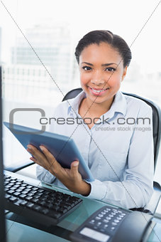 Smiling young dark haired businesswoman using a tablet pc