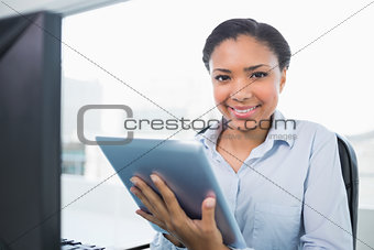 Joyful young dark haired businesswoman using a tablet pc