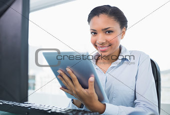 Amused young dark haired businesswoman using a tablet pc