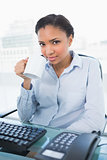 Pretty young dark haired businesswoman drinking a mug of coffee