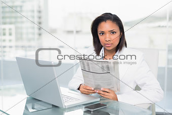 Stern young dark haired businesswoman holding a document
