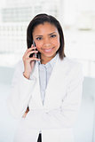 Content young dark haired businesswoman making a phone call