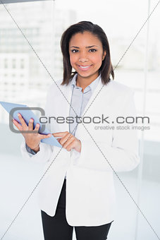 Pleased young dark haired businesswoman using a tablet pc