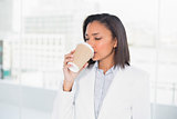 Cute young dark haired businesswoman enjoying coffee