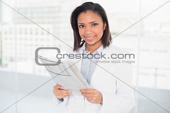 Amused young dark haired businesswoman holding a document