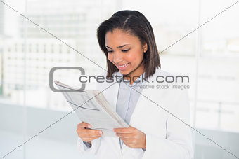 Attentive young dark haired businesswoman reading a document