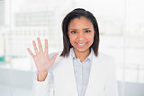 Pretty young dark haired businesswoman waving her hand