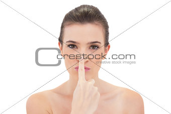 Playful natural brown haired model touching her nose