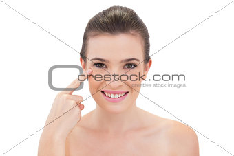 Content natural brown haired model touching her cheekbone