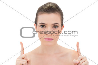 Unsmiling natural brown haired model raising her fingers