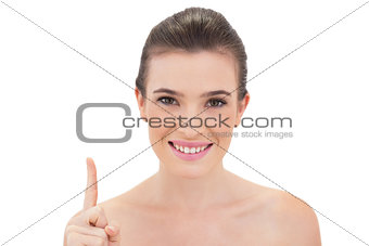 Pleased natural brown haired model raising her finger