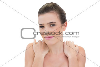 Worried natural brown haired model holding her shoulders
