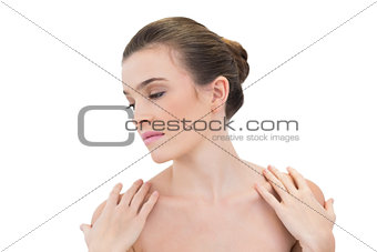 Calm natural brown haired model touching her shoulders