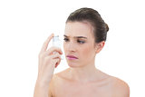Puzzled natural brown haired model looking at an asthma inhaler