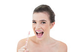 Cute natural brown haired model using a toothbrush