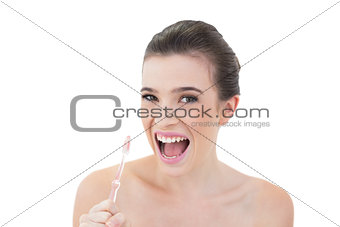 Cute natural brown haired model using a toothbrush