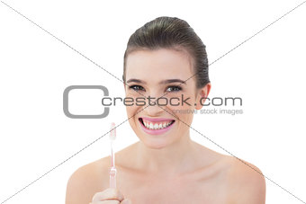 Delighted natural brown haired model holding a toothbrush