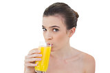 Lovely natural brown haired model drinking orange juice