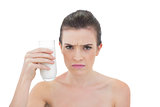 Frowning natural brown haired model holding a glass of milk