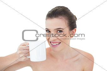 Joyful natural brown haired model holding a mug of coffee