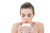 Peaceful natural brown haired model blowing on her coffee