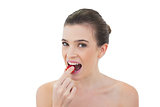 Attractive natural brown haired model eating a strawberry