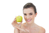 Seductive natural brown haired model showing a green apple
