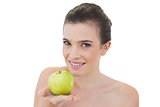 Happy natural brown haired model offering a green apple