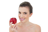 Relaxed natural brown haired model holding a red apple