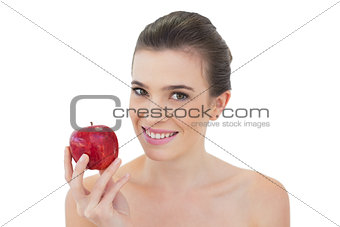 Relaxed natural brown haired model holding a red apple