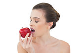 Relaxed natural brown haired model biting an apple