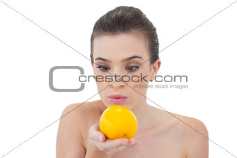 Shocked natural brown haired model looking at an orange