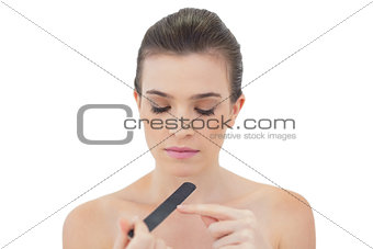 Pensive natural brown haired model filing her nails