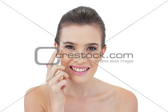 Attentive natural brown haired model applying face cream