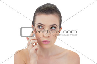 Pouting natural brown haired model applying face cream