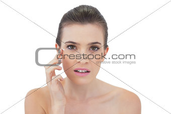 Beautiful natural brown haired model applying face cream
