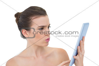 Troubled natural brown haired model using a tablet pc