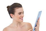 Pleased natural brown haired model using a tablet pc