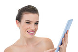 Cheerful natural brown haired model using a tablet pc