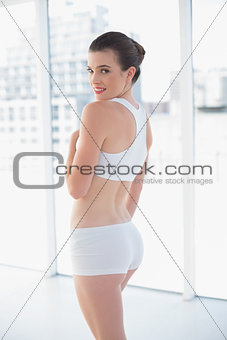 Content fit brown haired model in sportswear posing looking at camera