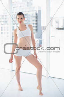 Charming fit brown haired model in sportswear posing looking at camera