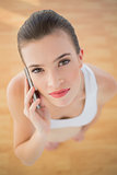 Serious fit brown haired model in sportswear making a phone call